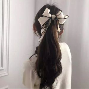 Elegant Pearl Banana Bow Clip Black and White